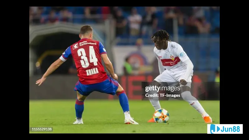 Cầu thủ của Basel đang dùng kỹ thuật để vượt qua cầu thủ Stuttgart trên sân cỏ